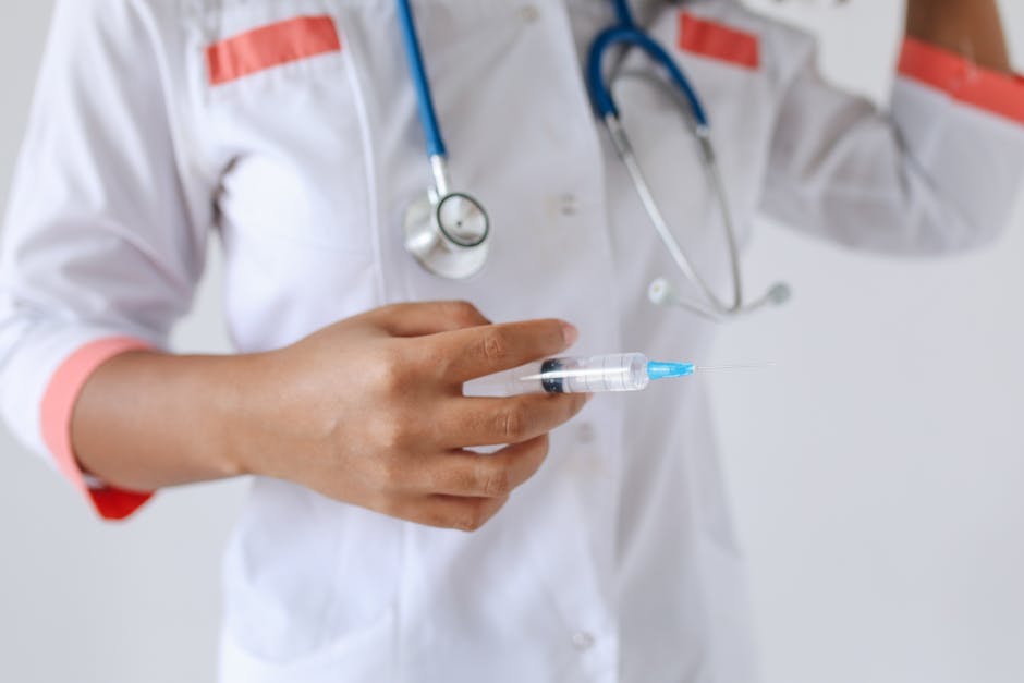 Doctor in white coat holding a syringe, ready for injection. Healthcare professional scene.