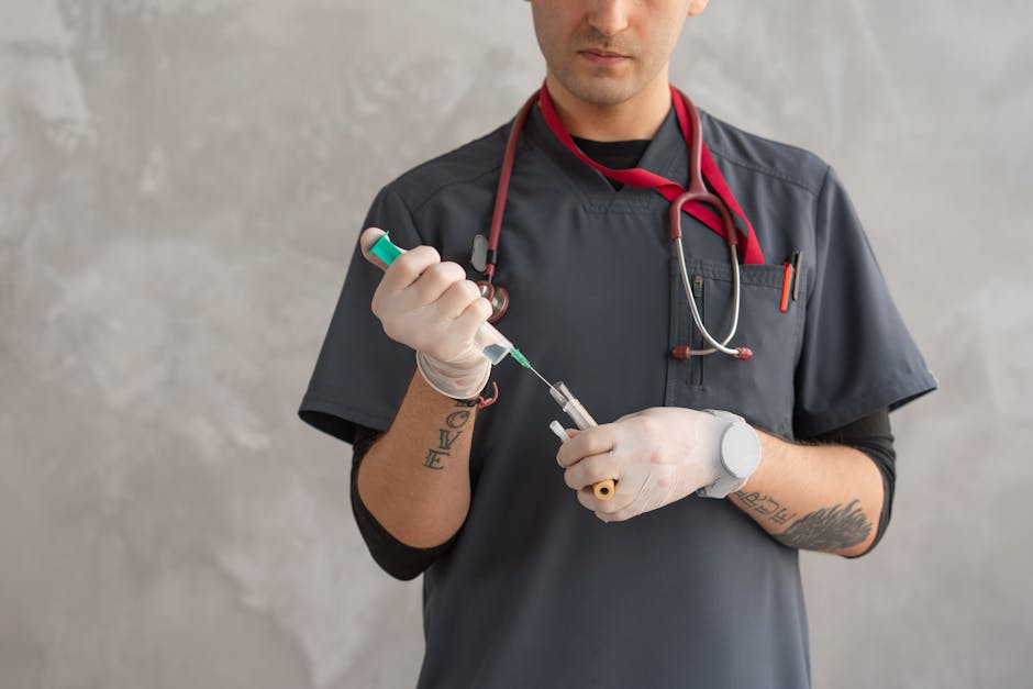A healthcare worker in scrubs prepares a syringe with precision.